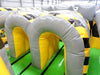 Image of Overhead angled view of inflatable obstacle course tunnels with gray arches and yellow caution-striped design