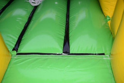 Close-up of green interior flooring inside the inflatable obstacle course showing heavy-duty vinyl surface
