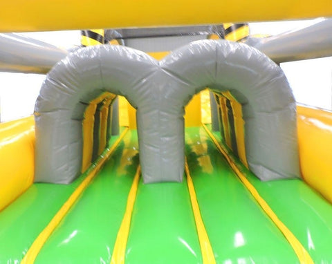 Dual tunnel entry inside green-floored inflatable obstacle course designed for races and crawl-through play