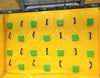 Image of Interior view of obstacle course wall with green foot pads and black climbing grips on a yellow vinyl surface