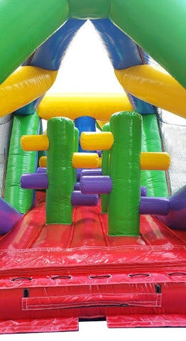Inside view of inflatable obstacle course showing red flooring and vertical pop-up obstacles for racing fun